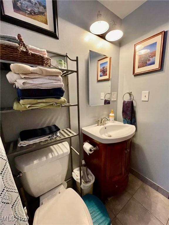 bathroom featuring tile patterned flooring, vanity, and toilet