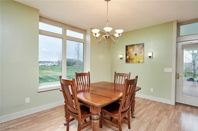 dining area with a chandelier and light hardwood / wood-style flooring