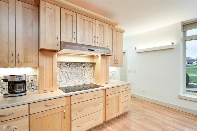 kitchen with black electric cooktop, decorative backsplash, light brown cabinets, and light hardwood / wood-style floors