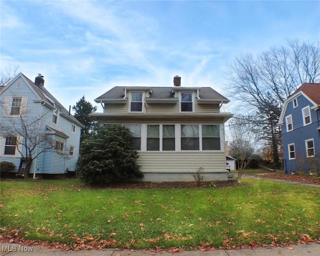 view of front of house with a sunroom and a front lawn