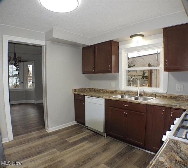 kitchen with dishwasher, dark hardwood / wood-style floors, sink, and an inviting chandelier