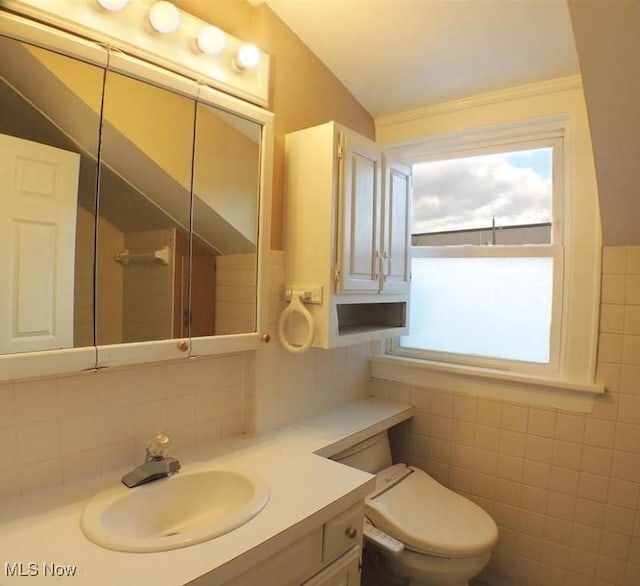 bathroom featuring vanity, vaulted ceiling, toilet, and tile walls