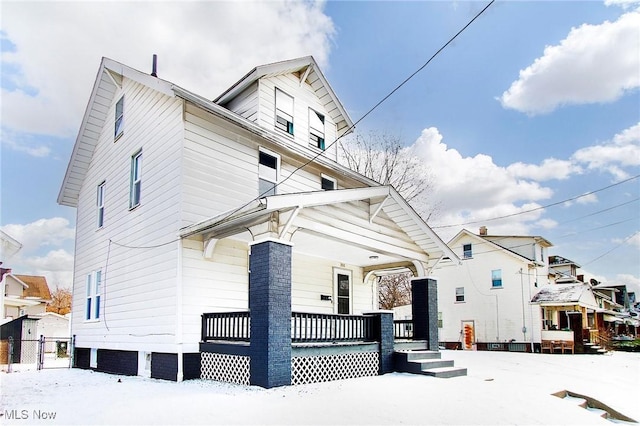 view of snowy exterior featuring a porch