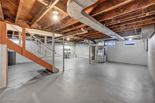 basement with gas water heater, heating unit, and sink