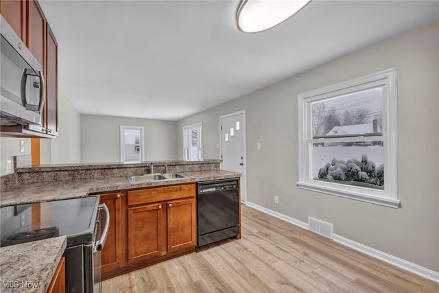 kitchen with light hardwood / wood-style floors, sink, and appliances with stainless steel finishes