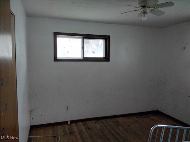 empty room featuring ceiling fan and dark wood-type flooring