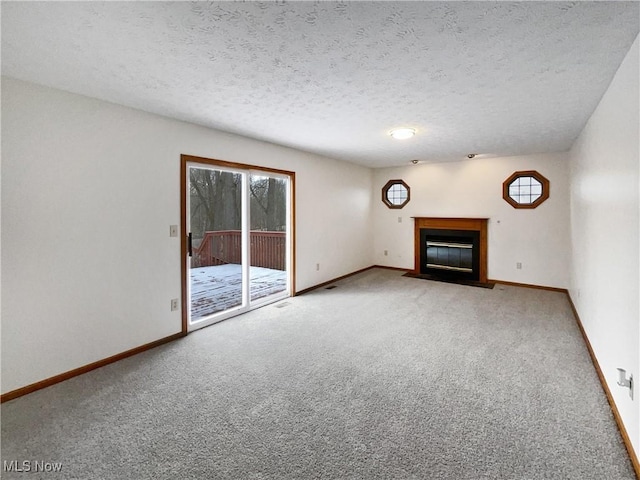 unfurnished living room with carpet flooring and a textured ceiling