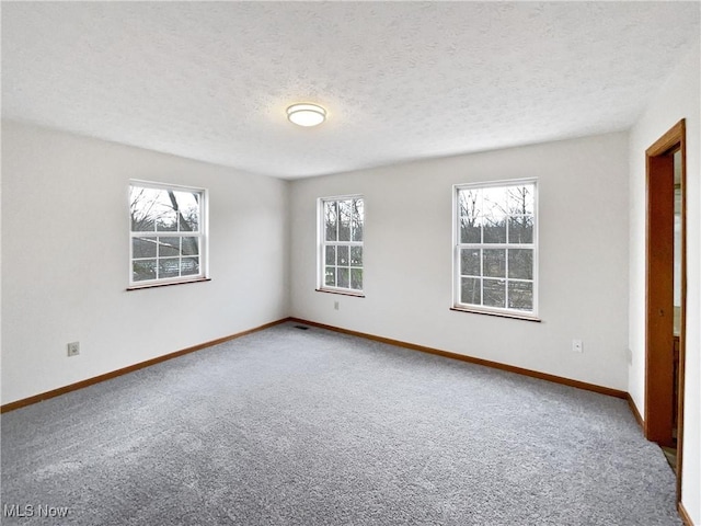 carpeted spare room featuring a textured ceiling