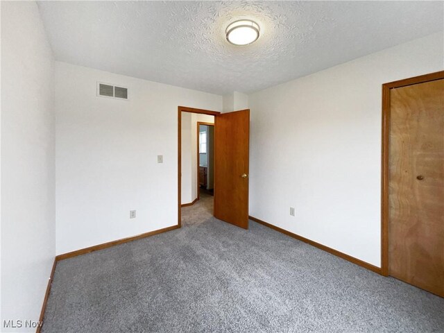 empty room featuring carpet floors and a textured ceiling