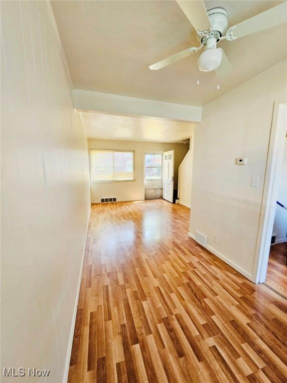 unfurnished living room featuring ceiling fan and light hardwood / wood-style flooring