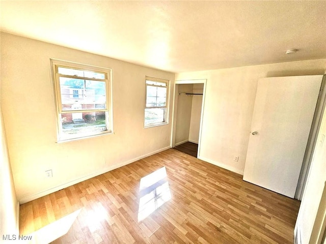 unfurnished bedroom with hardwood / wood-style floors and a closet