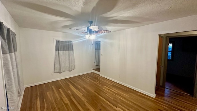 empty room with hardwood / wood-style flooring, ceiling fan, and a textured ceiling