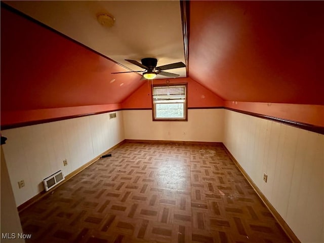 bonus room with ceiling fan, dark parquet flooring, and vaulted ceiling