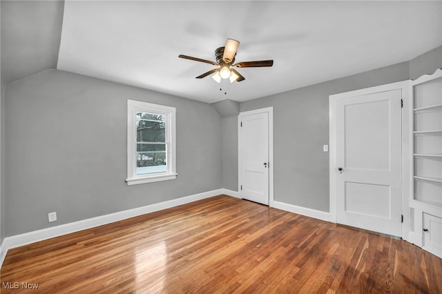 unfurnished bedroom featuring hardwood / wood-style floors, vaulted ceiling, and ceiling fan