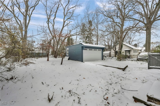 yard covered in snow with an outbuilding and a garage