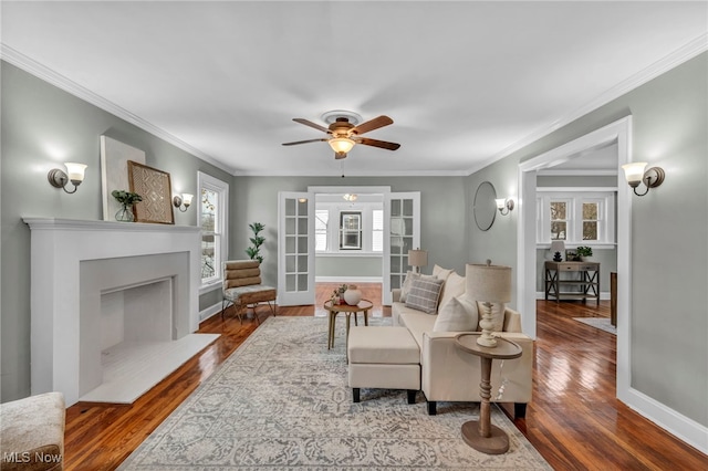 living room featuring hardwood / wood-style floors, ceiling fan, and crown molding