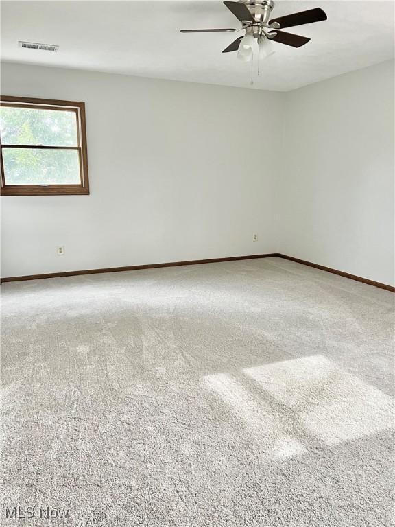 unfurnished room with carpet flooring and ceiling fan