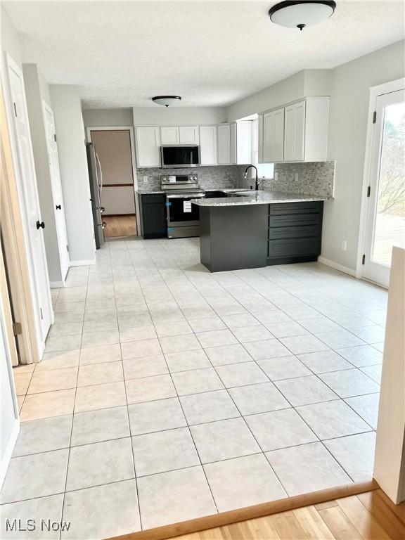 kitchen featuring white cabinets, decorative backsplash, sink, and stainless steel appliances