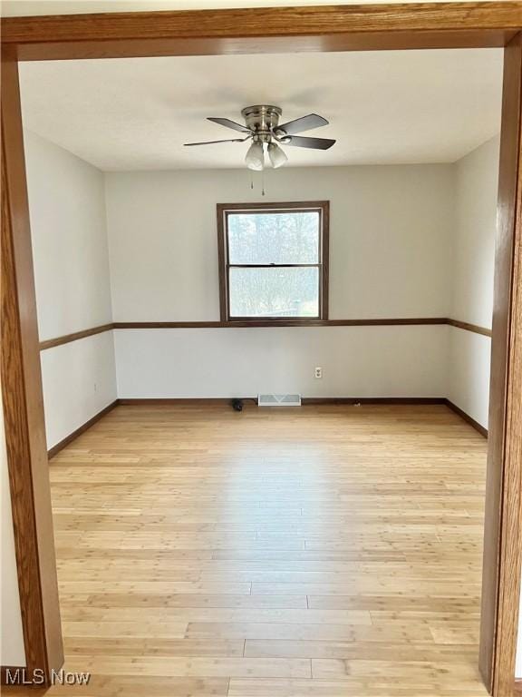 spare room featuring ceiling fan and light hardwood / wood-style flooring