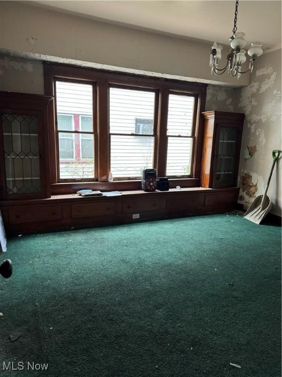 miscellaneous room with carpet flooring, a wealth of natural light, and a notable chandelier