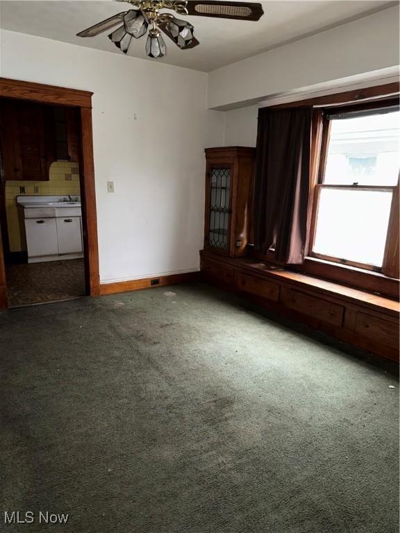 carpeted spare room featuring ceiling fan