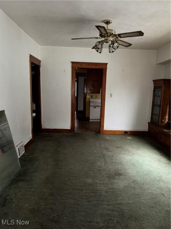 unfurnished living room featuring dark carpet and ceiling fan