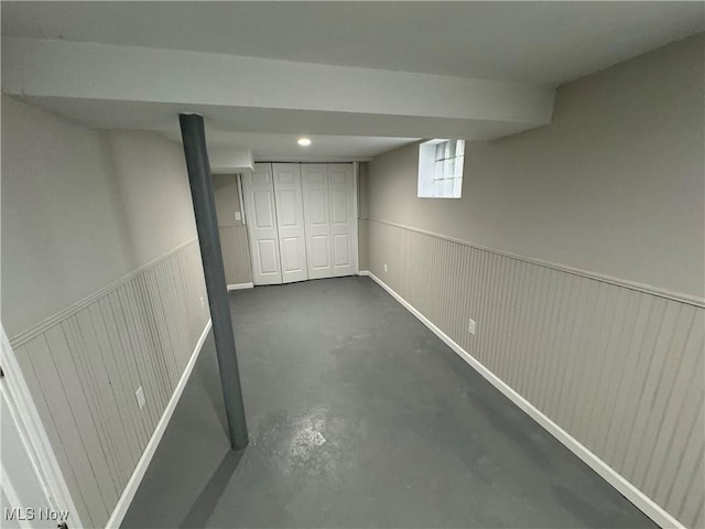 basement featuring wooden walls