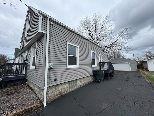 view of property exterior featuring a garage and an outbuilding