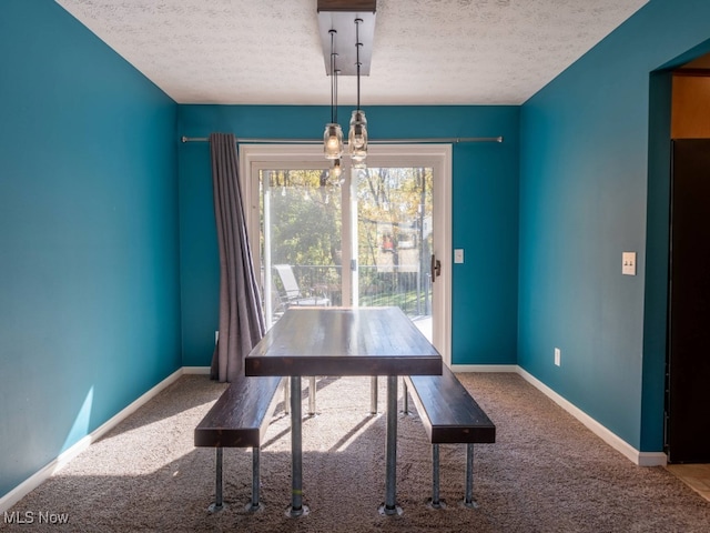 unfurnished dining area featuring carpet and a textured ceiling