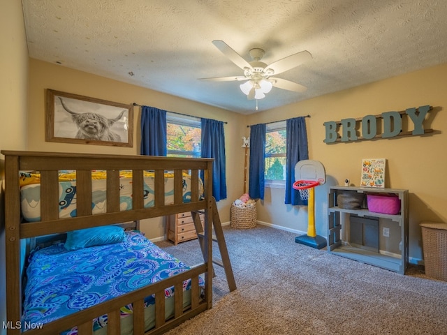 carpeted bedroom featuring ceiling fan and a textured ceiling