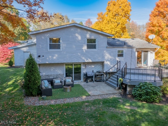 back of house with a wooden deck, an outdoor living space, a yard, and a patio