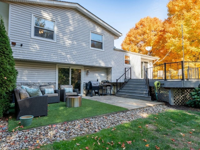 back of property featuring a wooden deck, an outdoor living space, and a patio