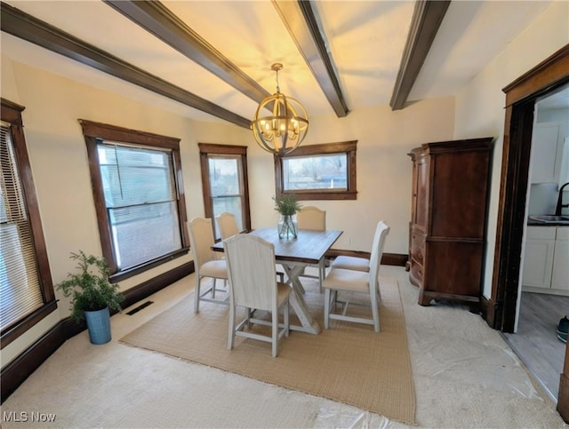 carpeted dining room featuring beam ceiling, sink, and an inviting chandelier