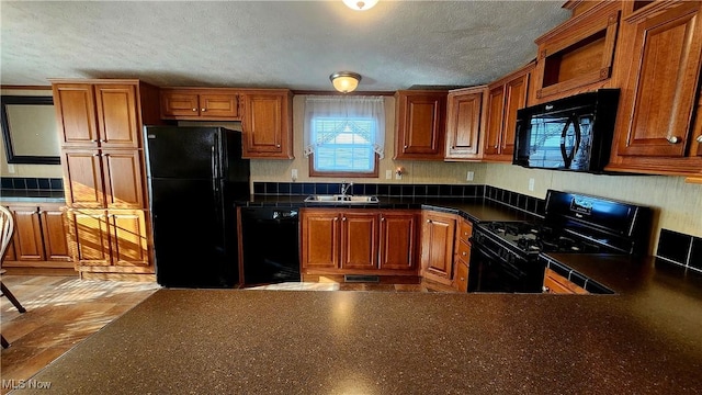 kitchen with sink, black appliances, and a textured ceiling