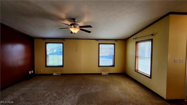 carpeted spare room with ceiling fan, crown molding, and a textured ceiling