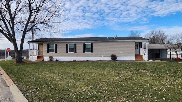 manufactured / mobile home with a carport and a front lawn