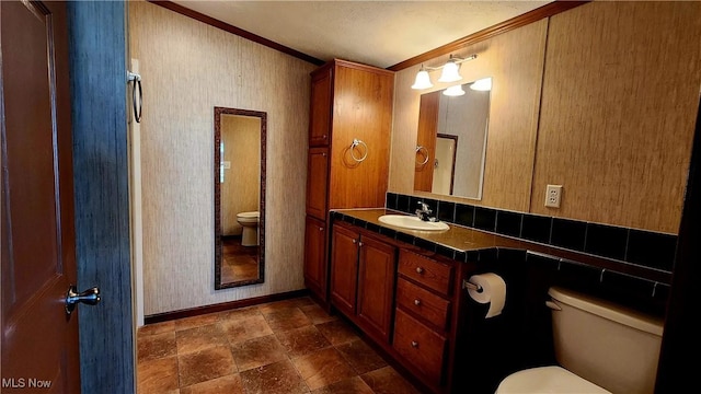 bathroom featuring vanity, toilet, and crown molding