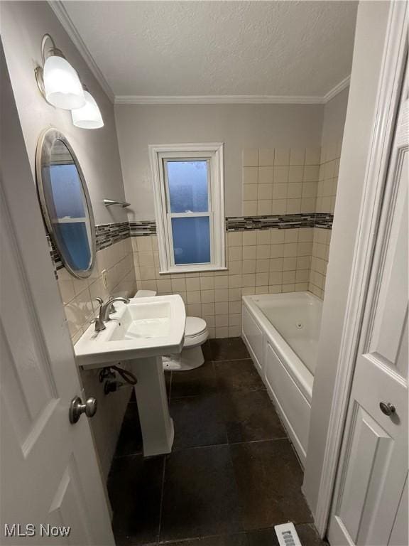 bathroom with tile patterned flooring, a bathtub, toilet, and tile walls