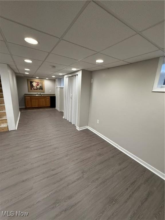 basement featuring a drop ceiling and wood-type flooring