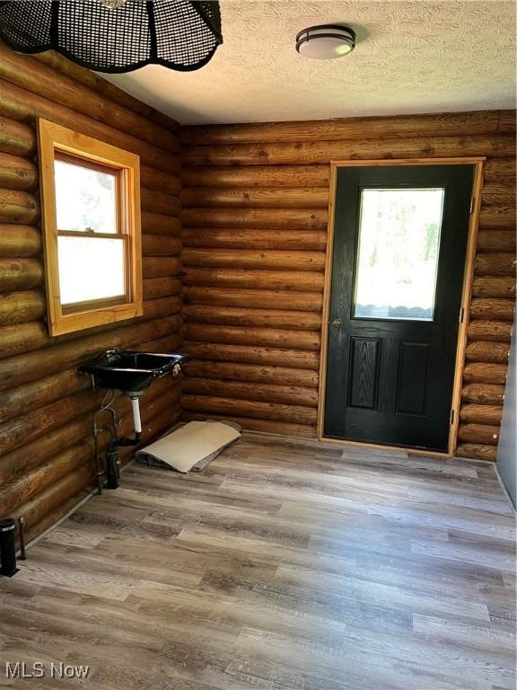 foyer featuring hardwood / wood-style floors and log walls