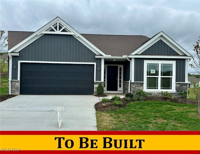 craftsman house with board and batten siding, stone siding, driveway, and an attached garage