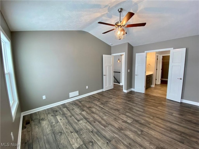 unfurnished bedroom with ceiling fan, dark hardwood / wood-style floors, connected bathroom, and vaulted ceiling