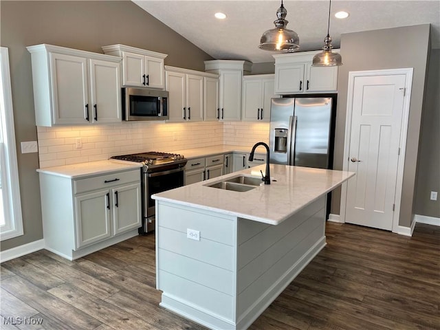 kitchen with pendant lighting, white cabinets, sink, dark hardwood / wood-style floors, and appliances with stainless steel finishes