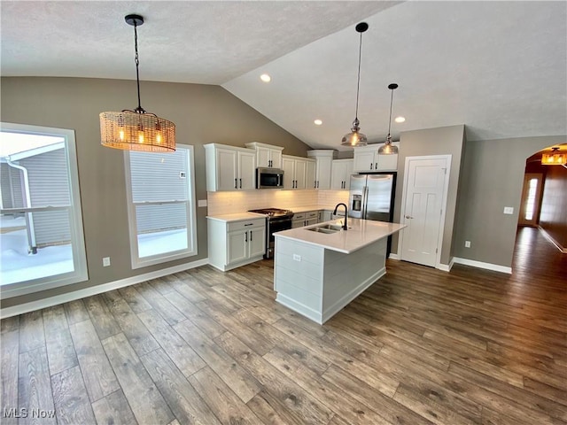 kitchen featuring pendant lighting, stainless steel appliances, white cabinetry, and sink