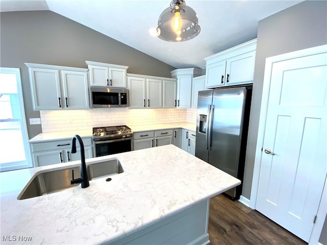 kitchen with dark hardwood / wood-style flooring, stainless steel appliances, vaulted ceiling, sink, and hanging light fixtures