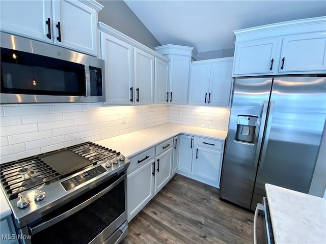 kitchen featuring decorative backsplash, appliances with stainless steel finishes, white cabinetry, and dark wood-type flooring