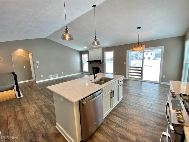 kitchen featuring appliances with stainless steel finishes, sink, a center island with sink, white cabinetry, and lofted ceiling