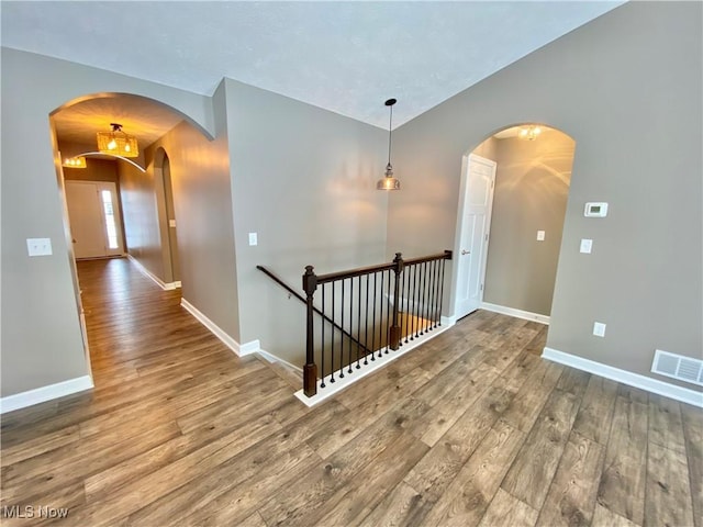 corridor with hardwood / wood-style flooring