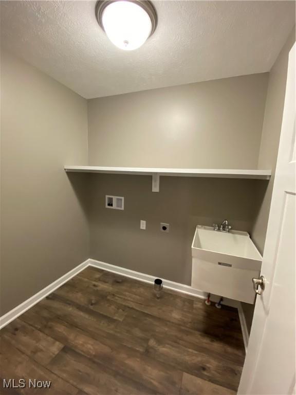 laundry room featuring washer hookup, a textured ceiling, dark wood-type flooring, and sink