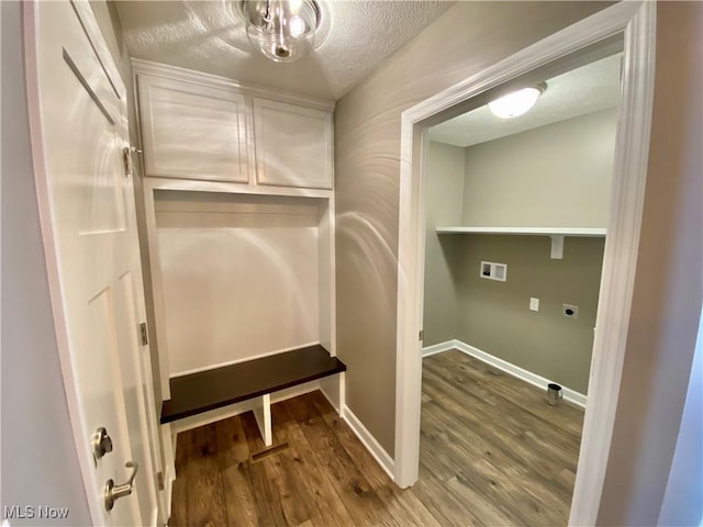 interior space with cabinets, electric dryer hookup, hookup for a washing machine, hardwood / wood-style floors, and a textured ceiling